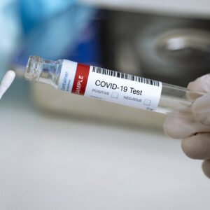 Testing for presence of coronavirus. Tube containing a swab testing for COVID-19.